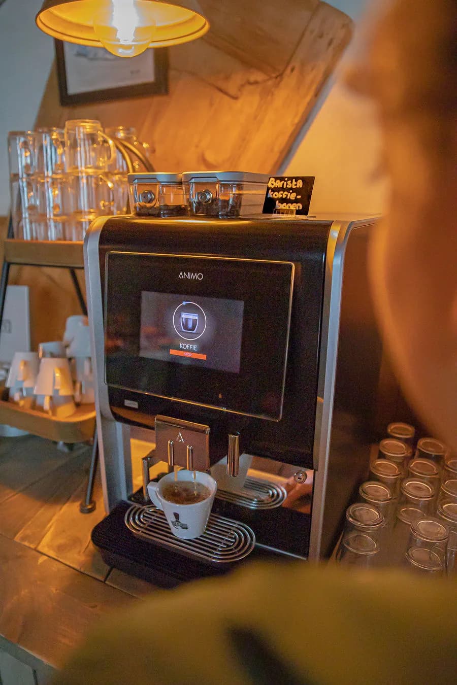 Koffiemachine met bordje barista-koffiebonen die een kopje koffie inschenkt